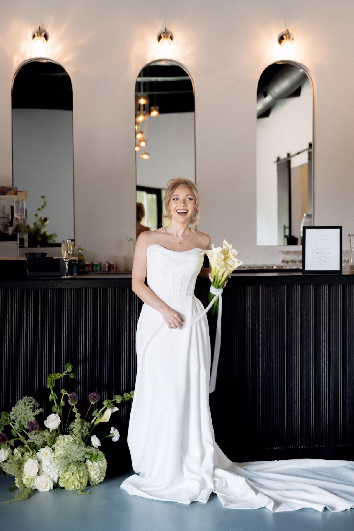 Bride in elegant white strapless gown holding calla lily bouquet at The Foxwood wedding venue in Hill Country Texas