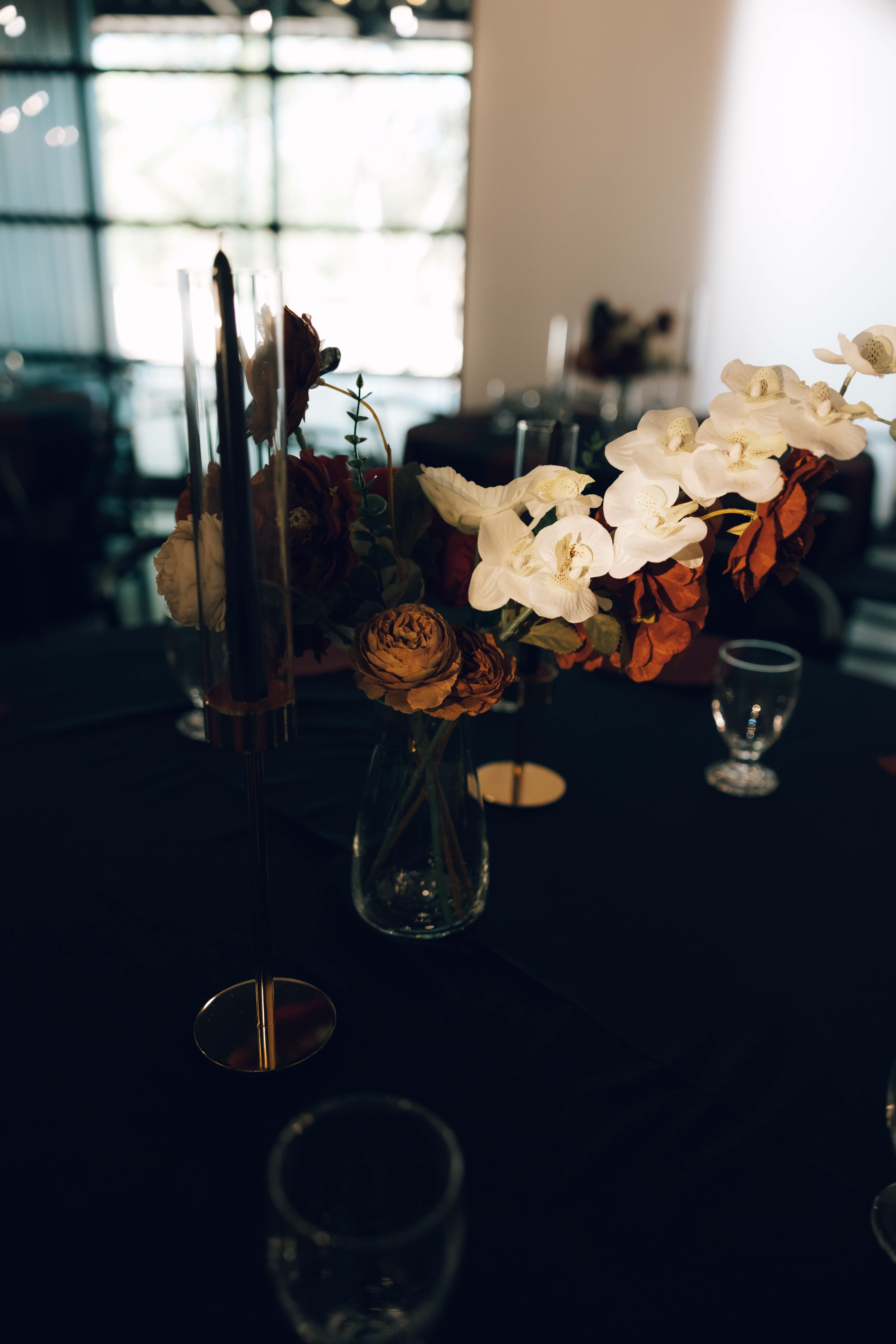 Elegant fall wedding centerpiece with white orchids and autumn roses at The Foxwood Hill Country Texas wedding venue