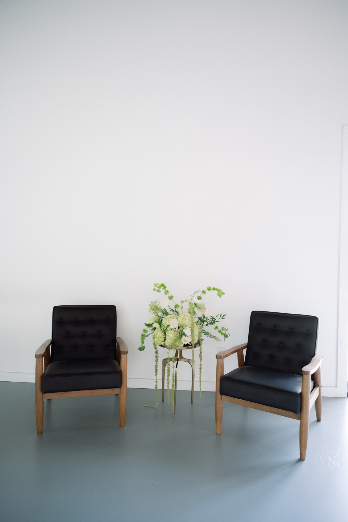 Modern black leather chairs with plant display at The Foxwood wedding venue in Hill Country Texas