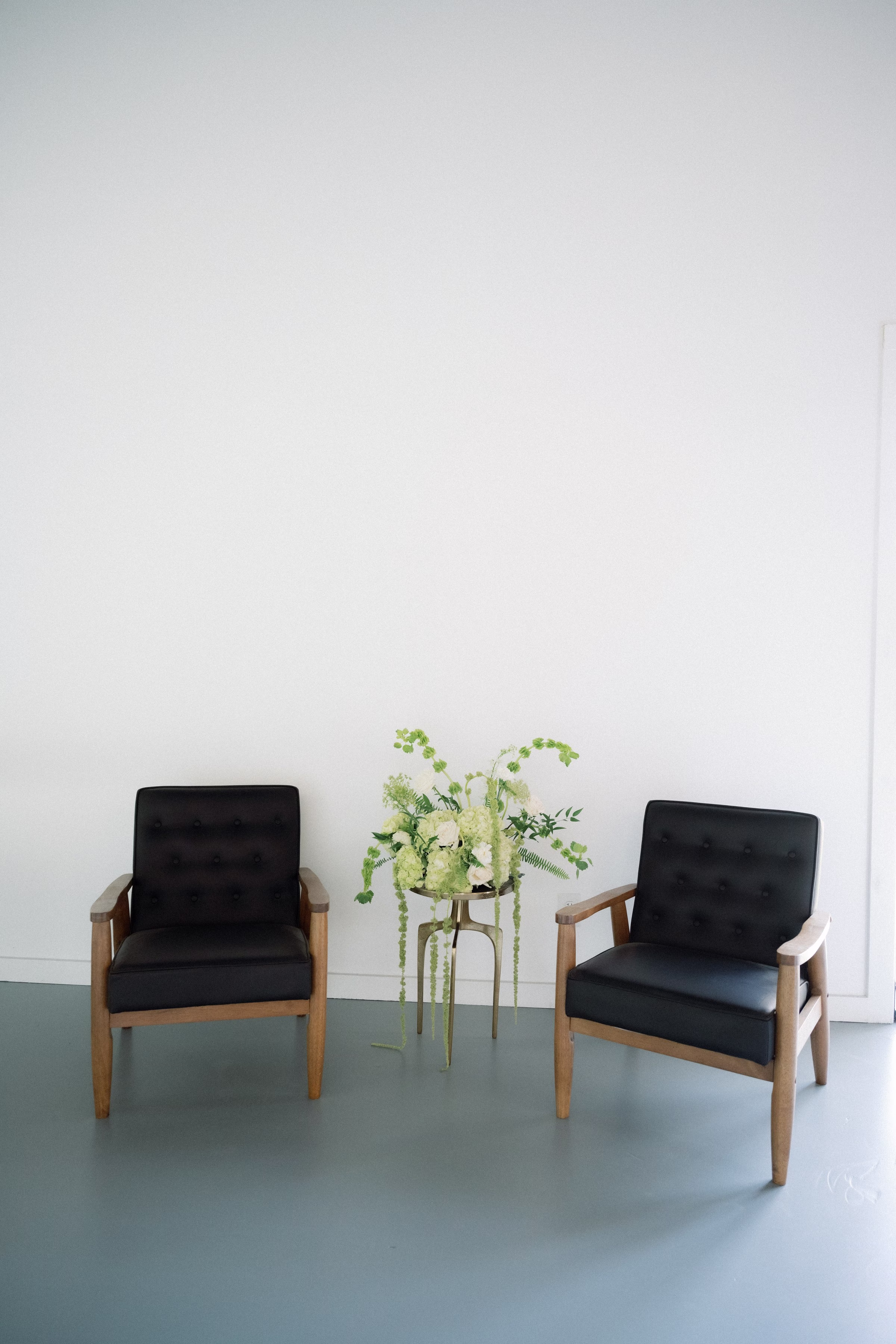 Modern black leather chairs with plant display at The Foxwood wedding venue in Hill Country Texas