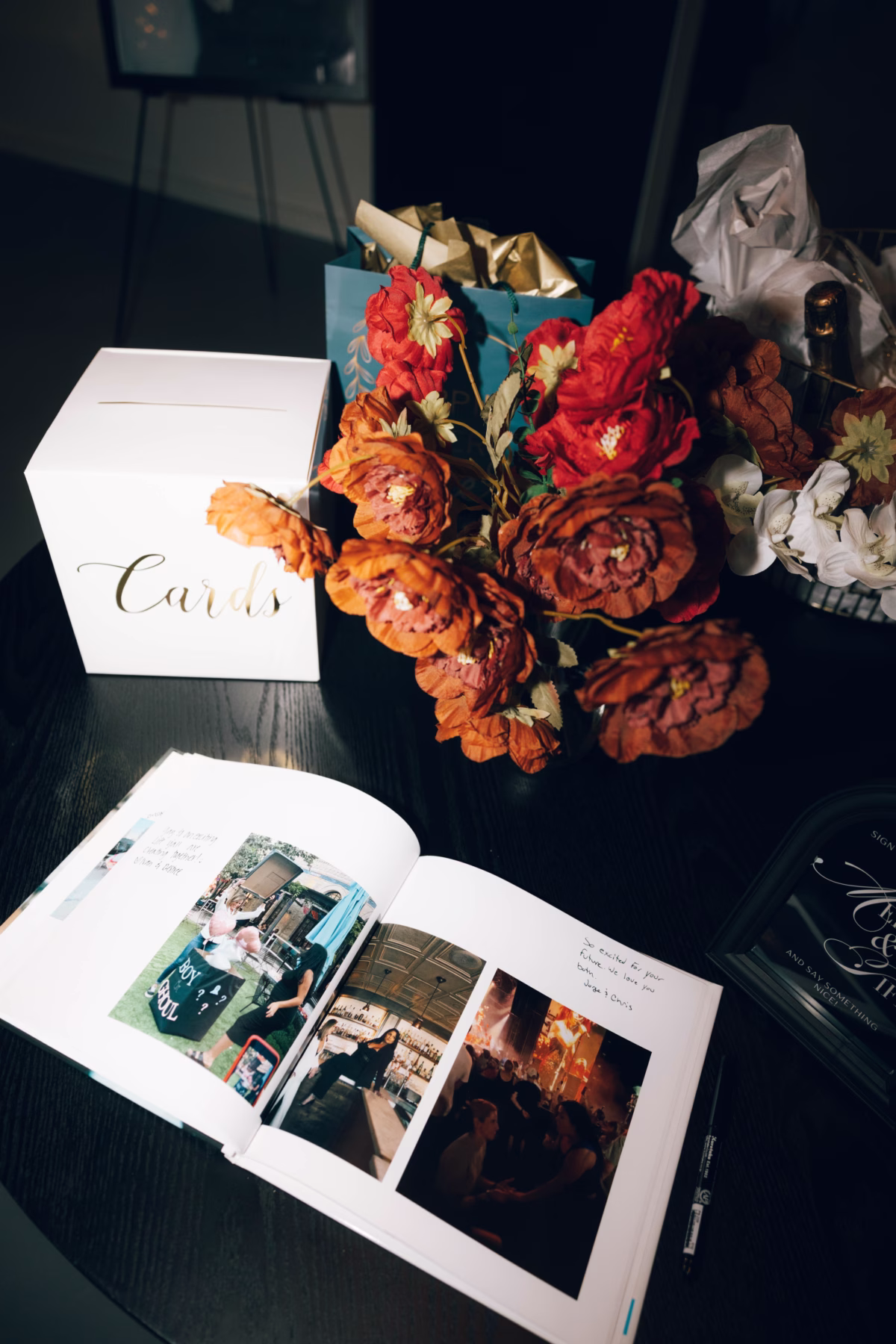 Wedding reception card table with autumn florals and photo album at The Foxwood venue in Canyon Lake Texas