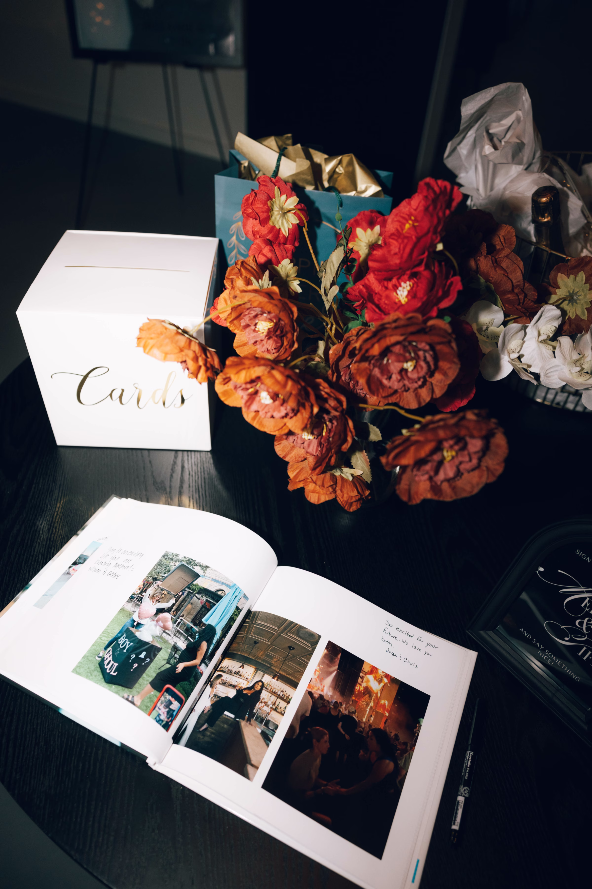 Wedding reception card table with autumn florals and photo album at The Foxwood venue in Canyon Lake Texas