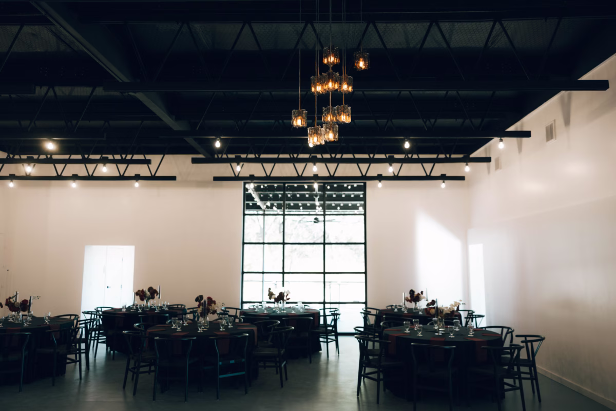 Elegant wedding reception setup with round tables and industrial lighting at The Foxwood wedding venue in Hill Country Texas
