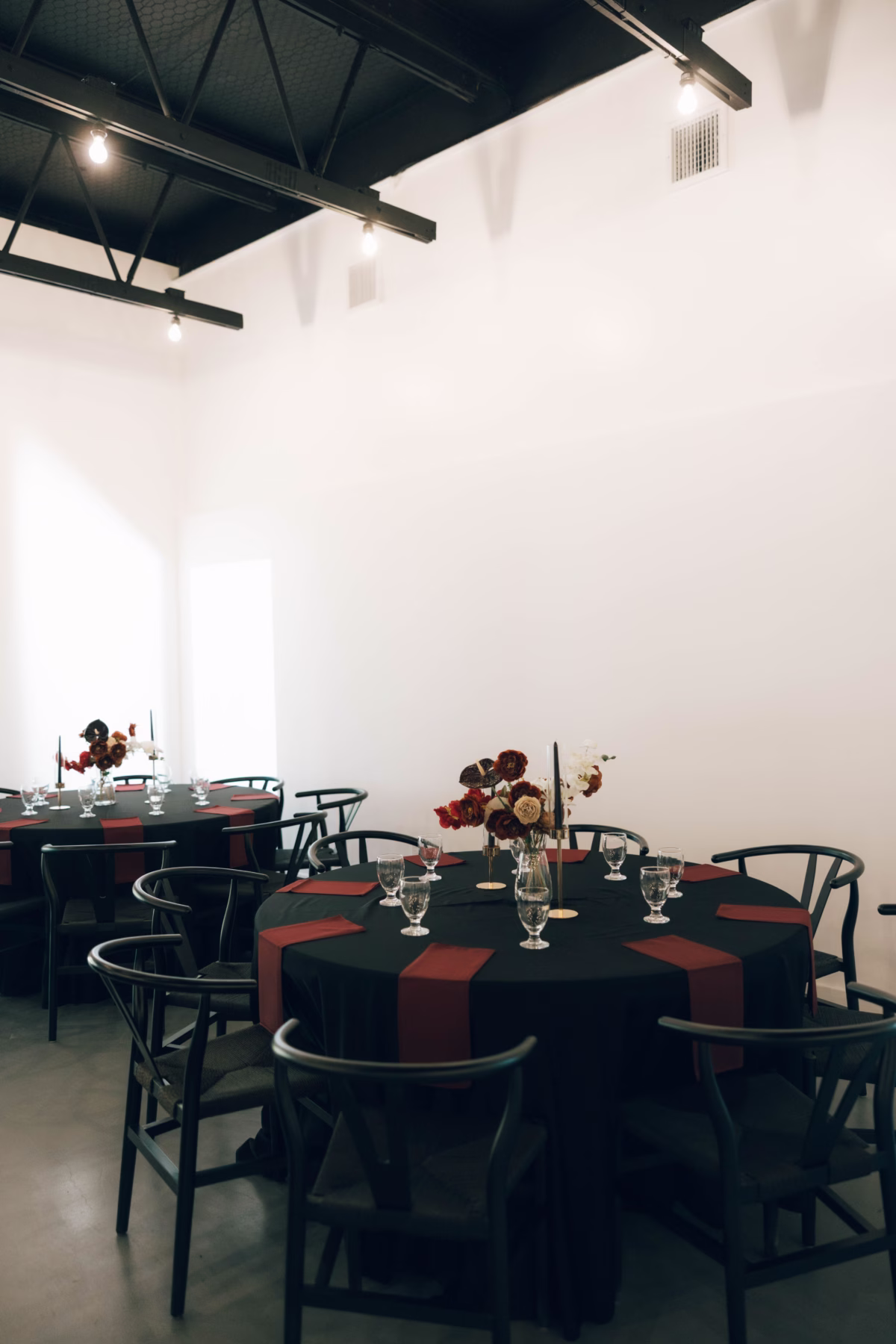 Elegant wedding reception tables with black linens and burgundy runners at The Foxwood wedding venue in Hill Country Texas