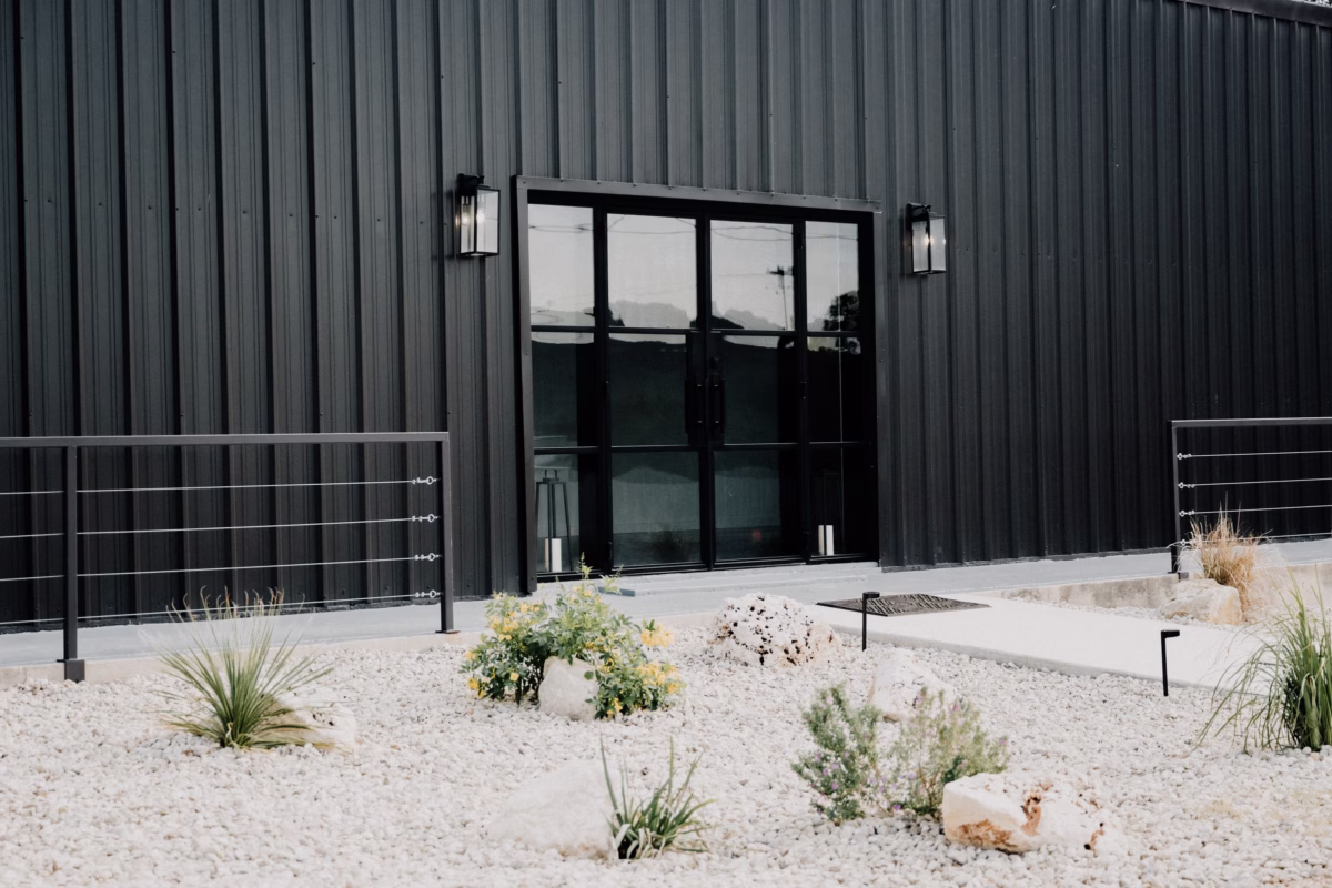 Modern industrial wedding venue exterior with corrugated metal siding and large windows at The Foxwood in Hill Country Texas