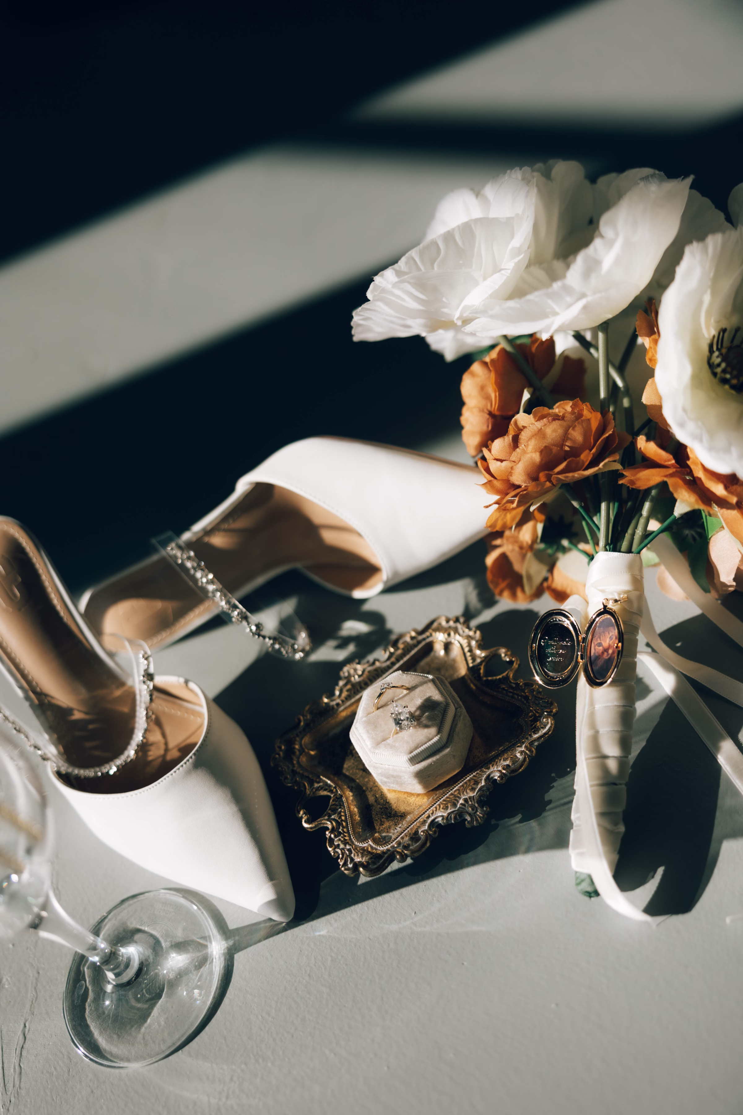 Elegant bridal wedding details including white heeled shoes, rings, and floral arrangement at The Foxwood Hill Country Texas wedding venue