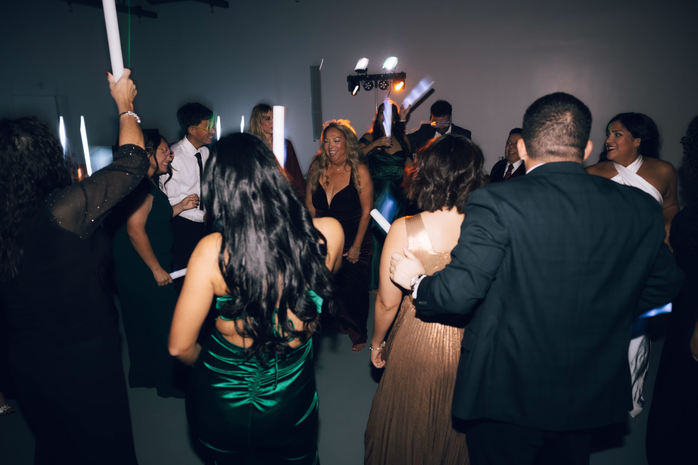Wedding guests dancing and celebrating at reception in Hill Country Texas venue The Foxwood with dramatic lighting and formal attire