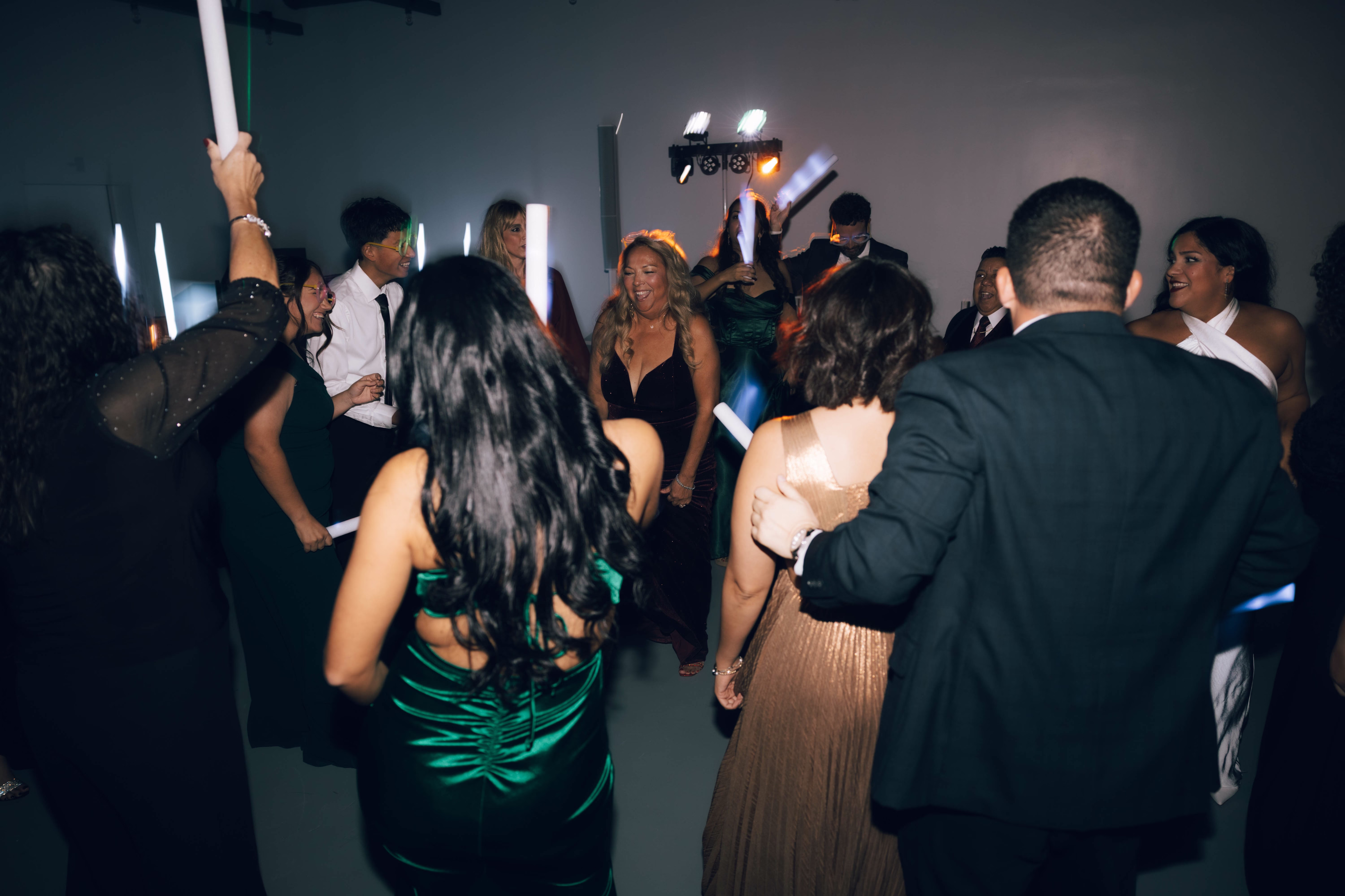 Wedding guests dancing and celebrating at reception in Hill Country Texas venue The Foxwood with dramatic lighting and formal attire